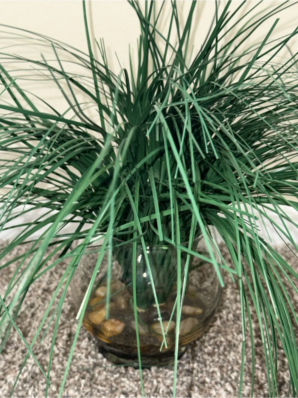 Artificial plant in glass round vase with rocks